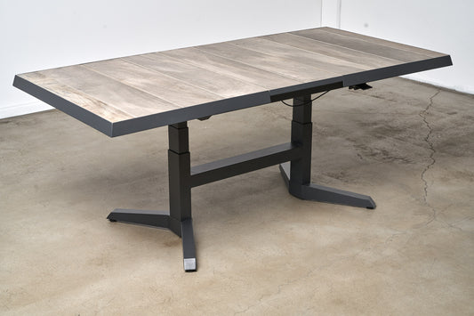 Wooden table with black metal legs on a concrete floor